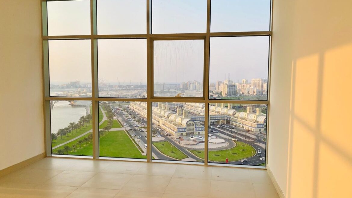 Interior view of a luxury 3-bedroom apartment in Al Majaz 1, Sharjah, featuring a spacious living area with modern furnishings and expansive sea-facing windows.-Propertyana real estate in dubai and sharjeh