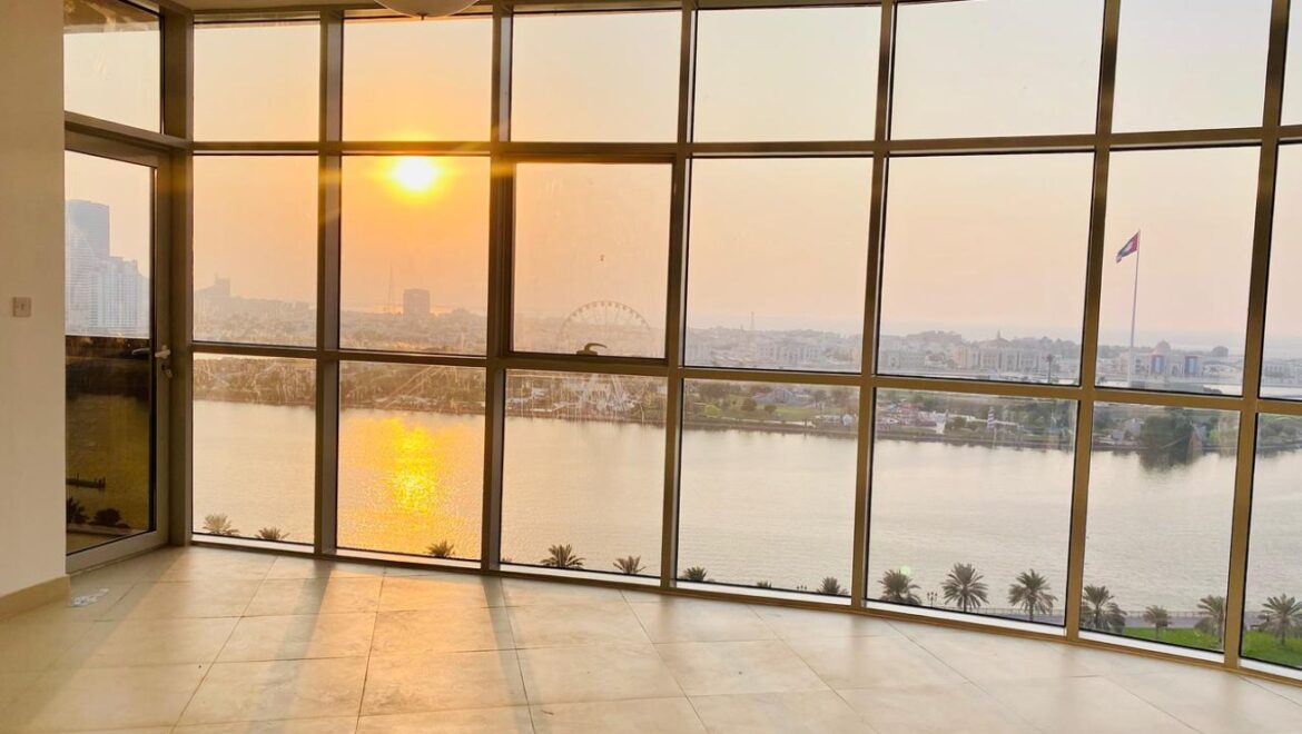 Interior view of a luxury 3-bedroom apartment in Al Majaz 1, Sharjah, featuring a spacious living area with modern furnishings and expansive sea-facing windows.-Propertyana real estate in dubai and sharjeh