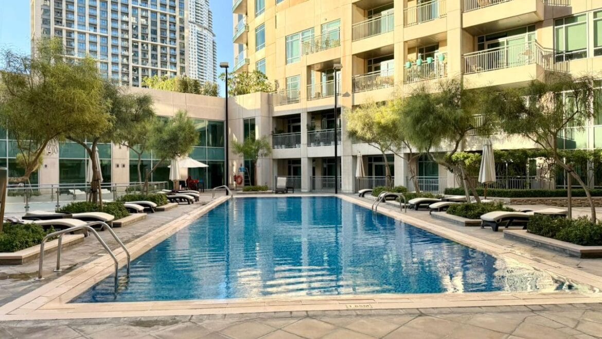 Studio bedroom interior in a residential apartment at Burj Views Podium, Downtown Dubai, featuring modern furnishings and a large window with city skyline views.-Propertyana real estate in dubai and sharjeh