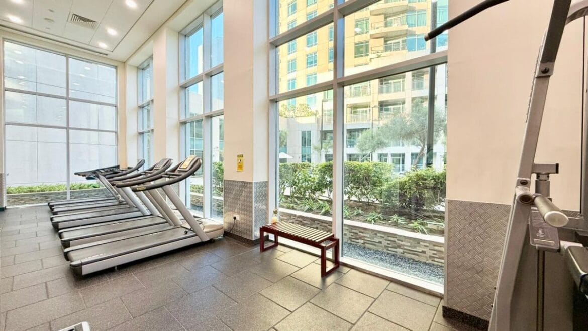 Studio bedroom interior in a residential apartment at Burj Views Podium, Downtown Dubai, featuring modern furnishings and a large window with city skyline views.-Propertyana real estate in dubai and sharjeh