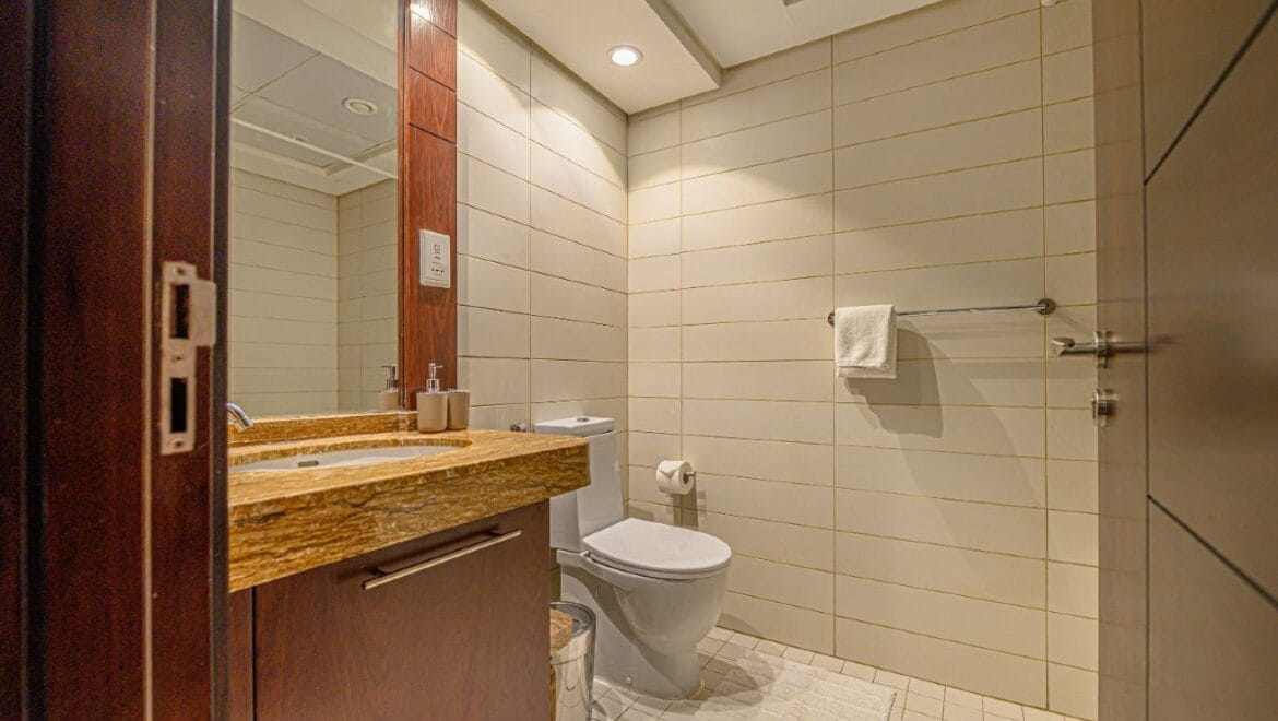 Studio bedroom interior in a residential apartment at Burj Views Podium, Downtown Dubai, featuring modern furnishings and a large window with city skyline views.-Propertyana real estate in dubai and sharjeh