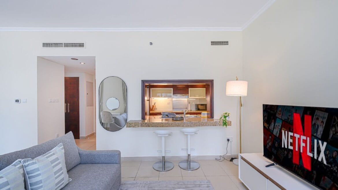 Studio bedroom interior in a residential apartment at Burj Views Podium, Downtown Dubai, featuring modern furnishings and a large window with city skyline views.-Propertyana real estate in dubai and sharjeh