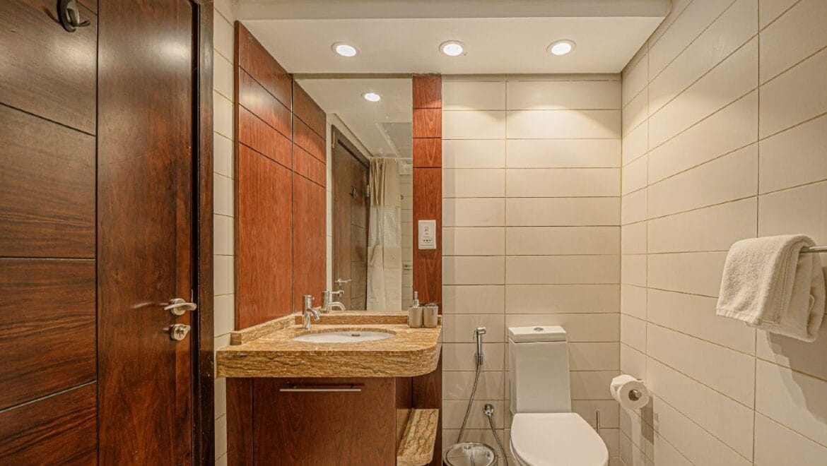 Studio bedroom interior in a residential apartment at Burj Views Podium, Downtown Dubai, featuring modern furnishings and a large window with city skyline views.-Propertyana real estate in dubai and sharjeh