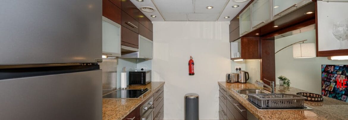 Studio bedroom interior in a residential apartment at Burj Views Podium, Downtown Dubai, featuring modern furnishings and a large window with city skyline views.-Propertyana real estate in dubai and sharjeh