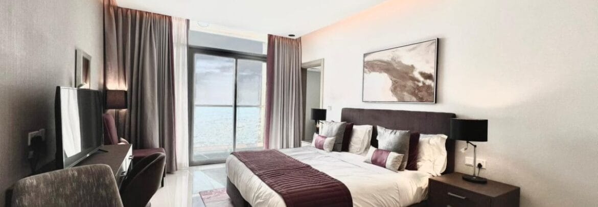 Studio bedroom in a luxury residential apartment at Aykon City Tower B, Business Bay, Dubai, featuring contemporary decor, a compact study area, and large windows with skyline views.-Propertyana real estate in dubai and sharjeh