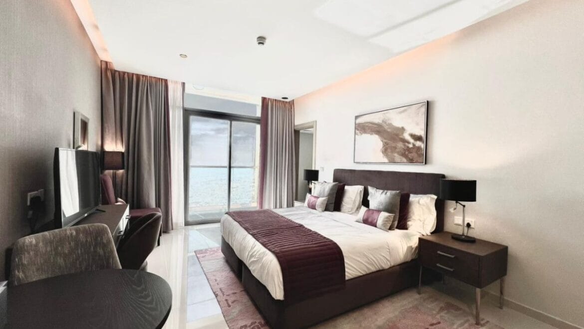 Studio bedroom in a luxury residential apartment at Aykon City Tower B, Business Bay, Dubai, featuring contemporary decor, a compact study area, and large windows with skyline views.-Propertyana real estate in dubai and sharjeh