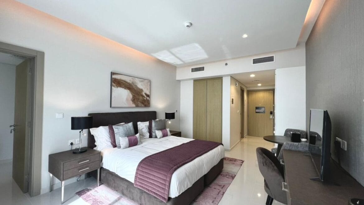 Studio bedroom in a luxury residential apartment at Aykon City Tower B, Business Bay, Dubai, featuring contemporary decor, a compact study area, and large windows with skyline views.-Propertyana real estate in dubai and sharjeh