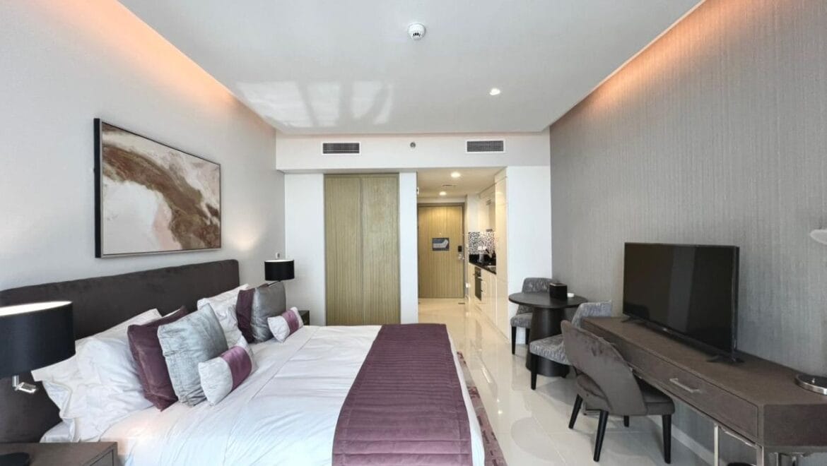 Studio bedroom in a luxury residential apartment at Aykon City Tower B, Business Bay, Dubai, featuring contemporary decor, a compact study area, and large windows with skyline views.-Propertyana real estate in dubai and sharjeh